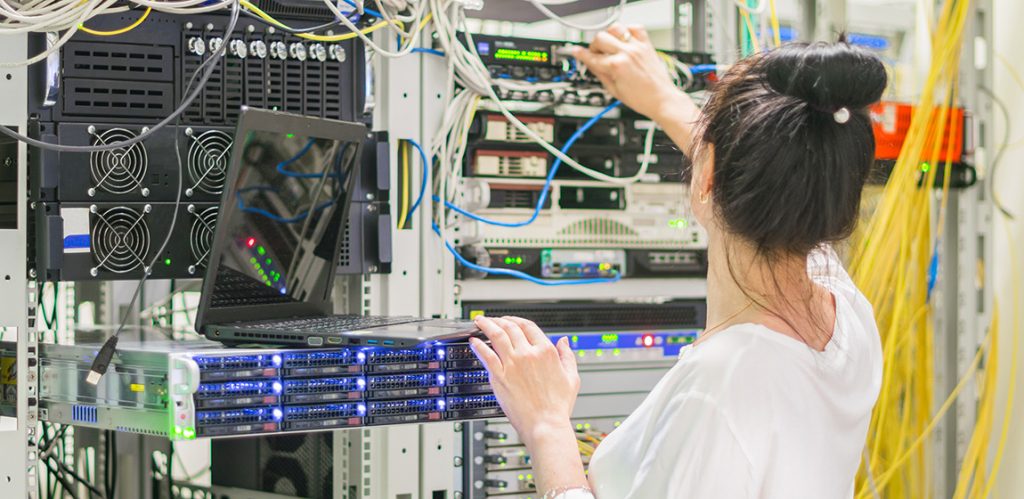 lady working with networking banks of computers