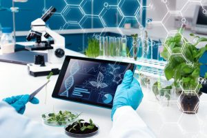 biology desk with microscope, plants and screen